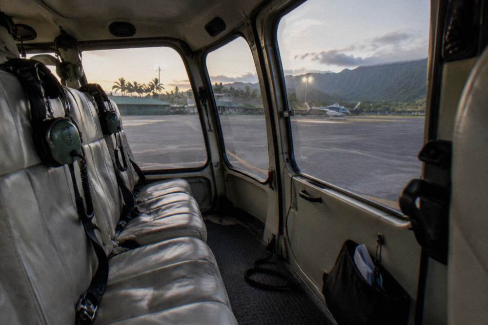 A helicopter cabin interior showing headsets on empty seats before a flight