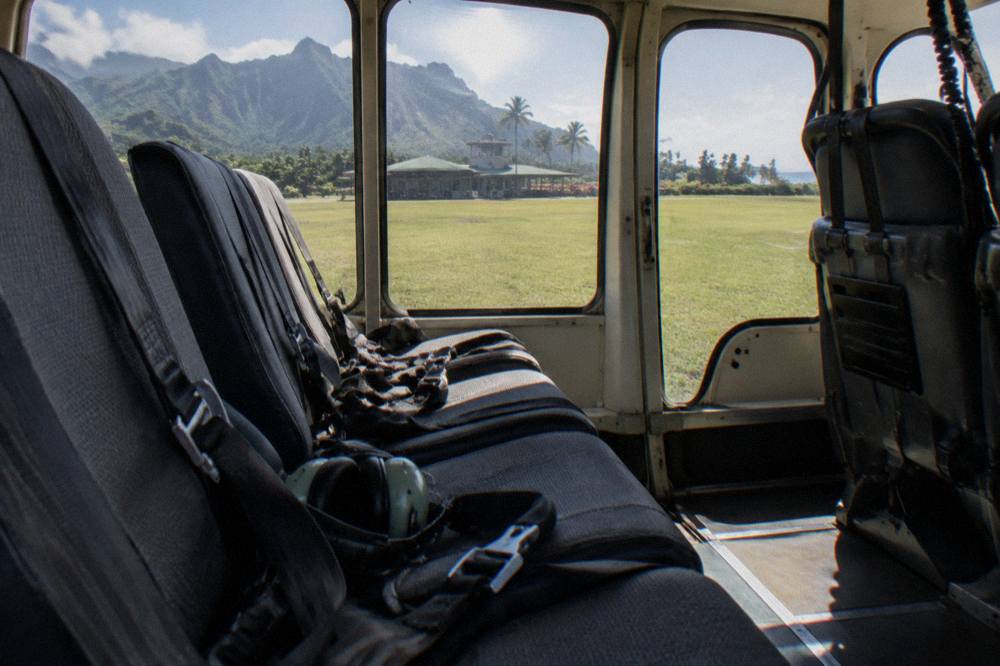 A doors-on helicopter cabin interior with rows of passenger seats and large windows