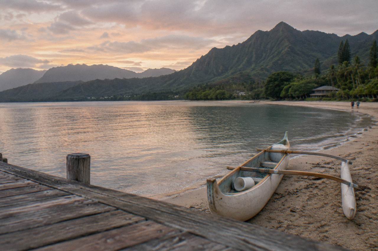 A calm bay on Kauai with green ridges rising behind the shoreline