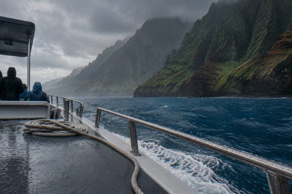 Green sea cliffs dropping straight into deep blue ocean along a remote coastline