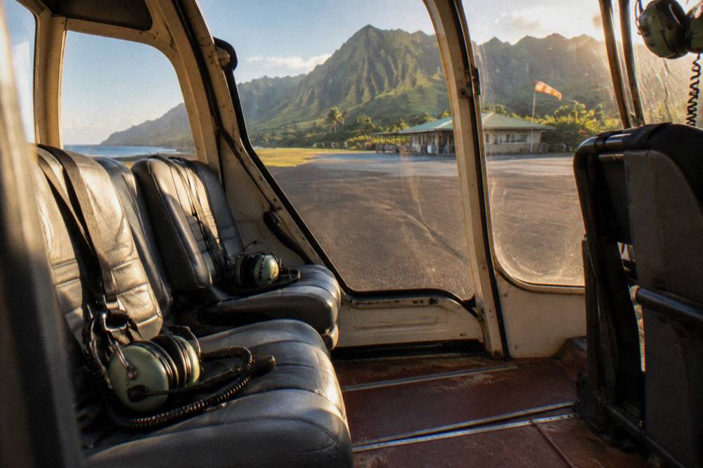 A helicopter cabin interior with headsets resting on empty seats before a flight