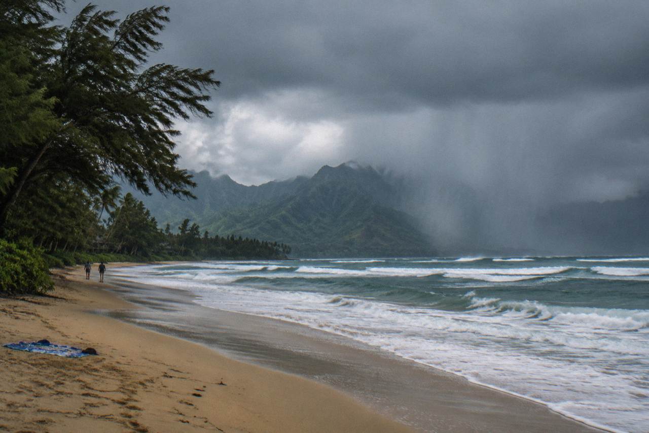 Rain clouds drifting over green Kauai mountains near the coast