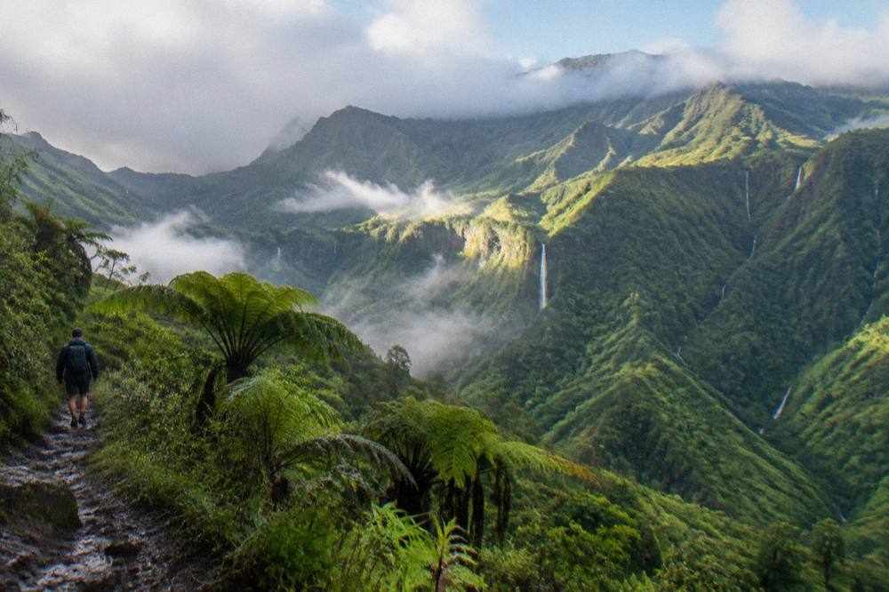 Morning light over green Kauai ridges with scattered clouds in the valleys