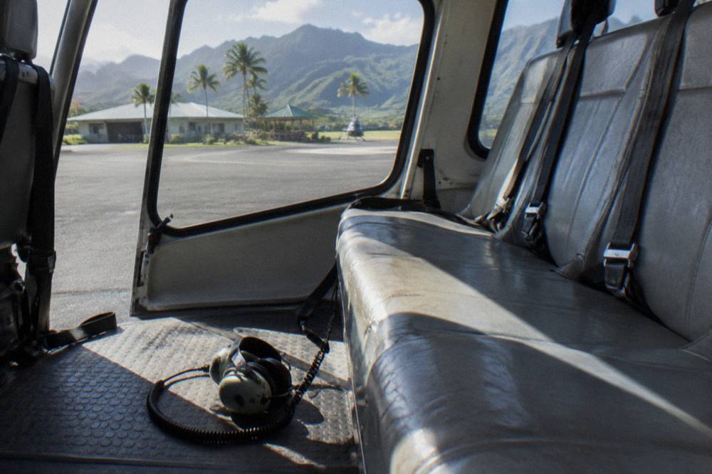 A helicopter cabin interior with empty passenger seats in morning light