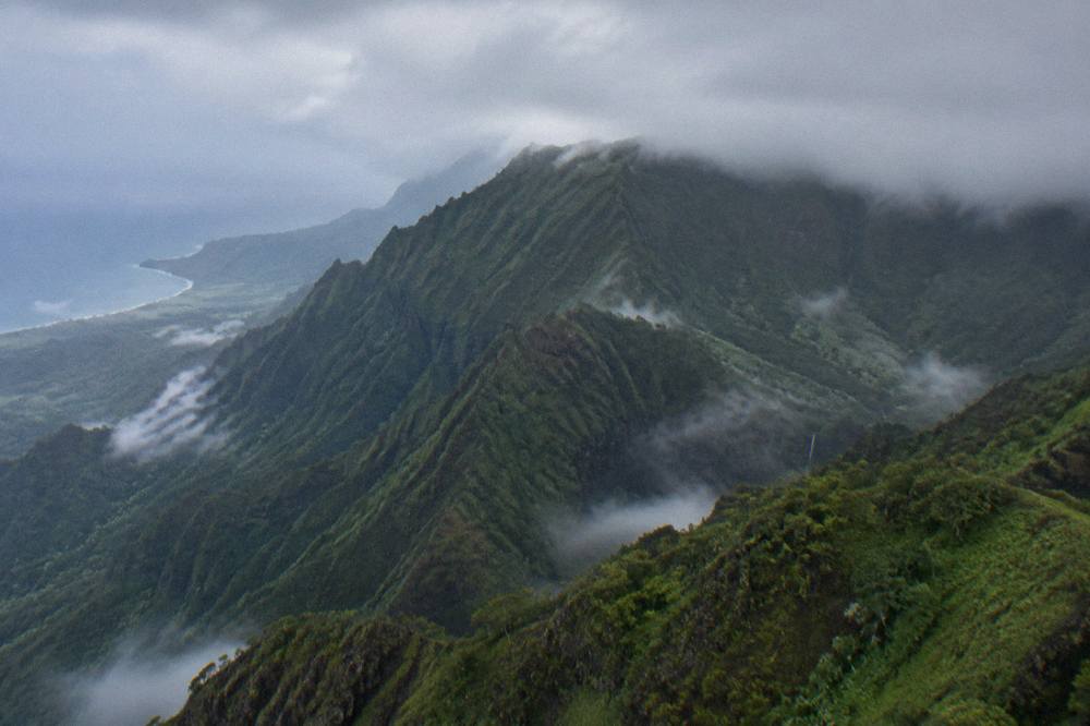 Clouds resting on green mountain ridges above a Kauai valley