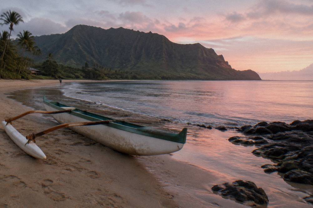 A quiet coastal bay with green cliffs and calm water in morning light