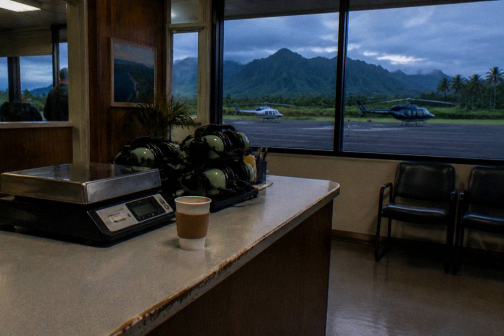 Check-in counter area of a small helicopter tour office with a scale and seating