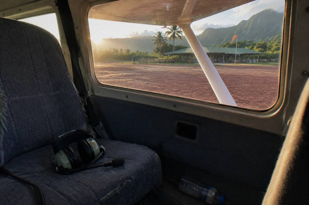 A helicopter cabin interior with headset on an empty passenger seat before boarding