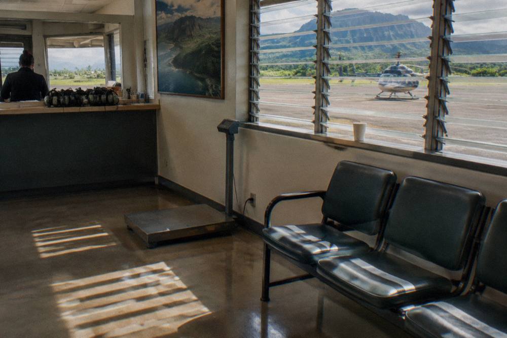 A check-in counter at a helicopter tour office with a scale beside the seating area