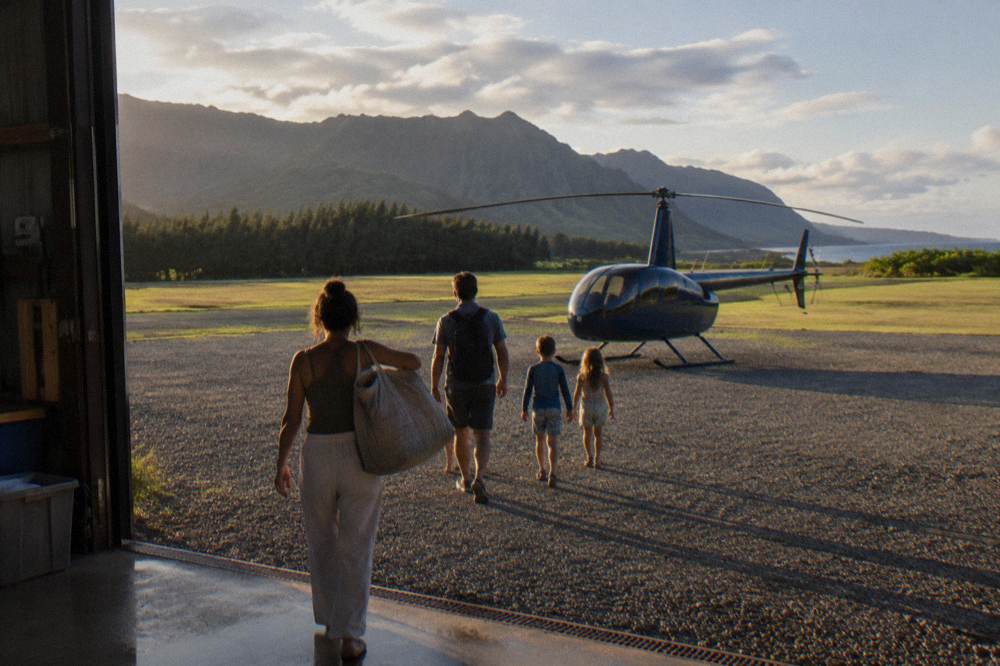 A family walking across a heliport apron toward a waiting helicopter