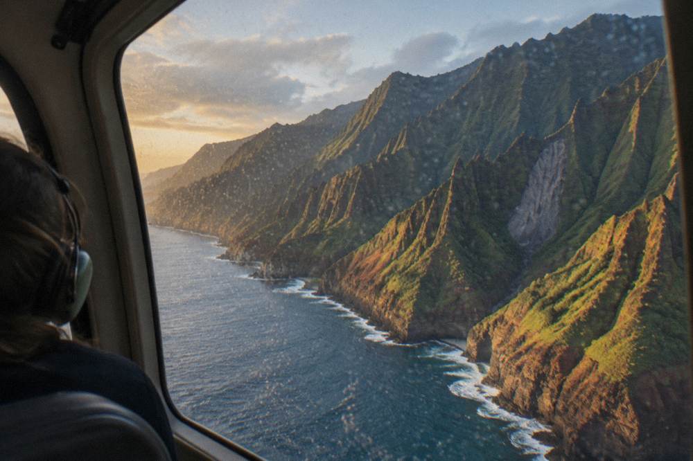 A helicopter flying along a rugged coastline with tall sea cliffs