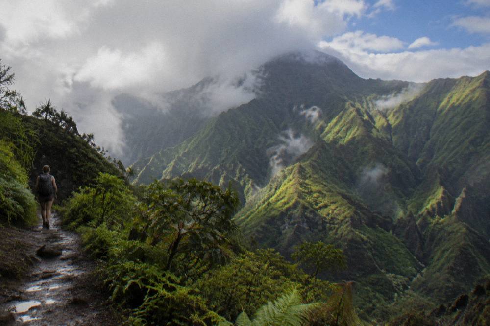 Sunlight breaking over green Kauai valleys with scattered clouds
