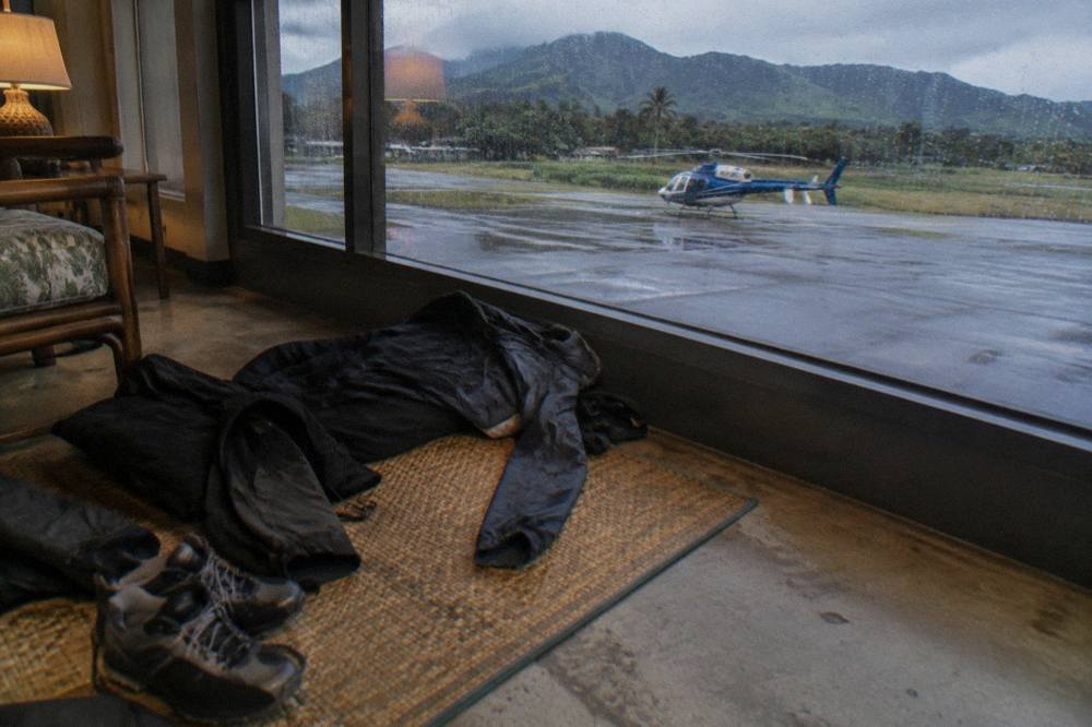 Dark layered clothing and closed-toe shoes laid out for a helicopter flight